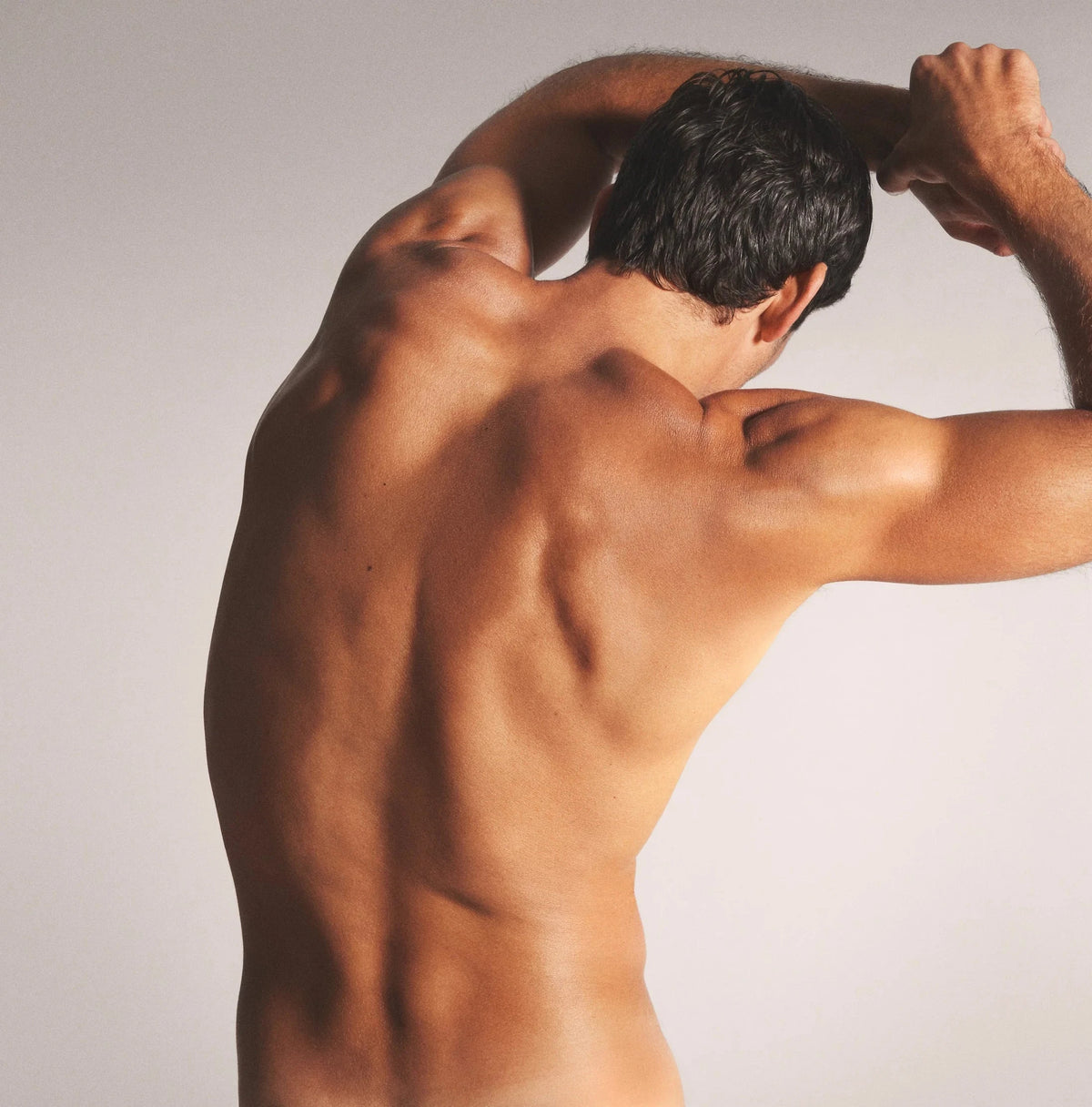 Person shown from behind with bare shoulders and upper back